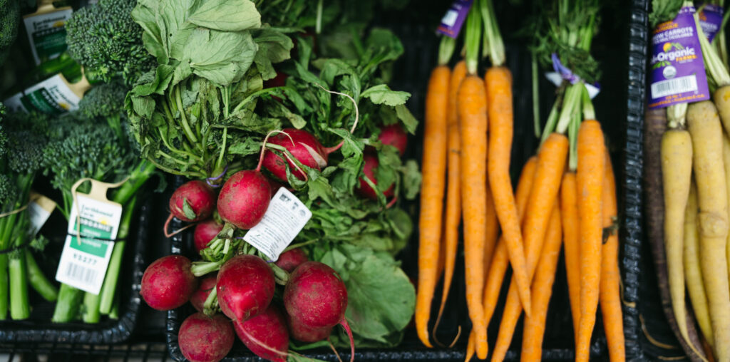 Fresh organic radishes, carrots, and broccoli displayed at Earthbound Farm during a CCOF Foundation event in 2026